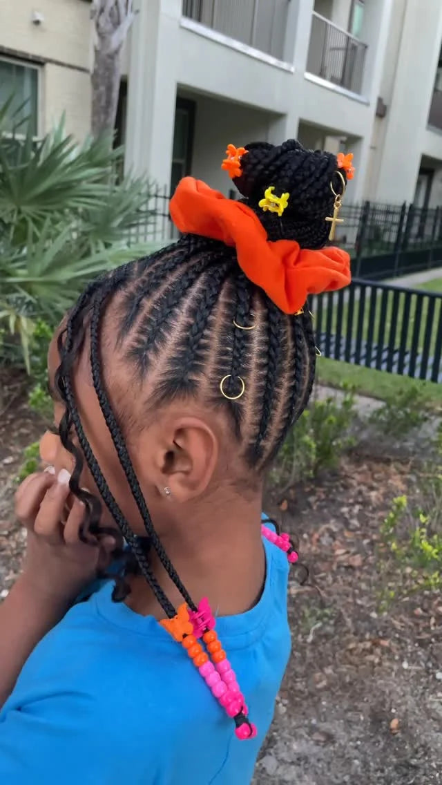 Person with braided hair wearing colorful hair ties outdoors