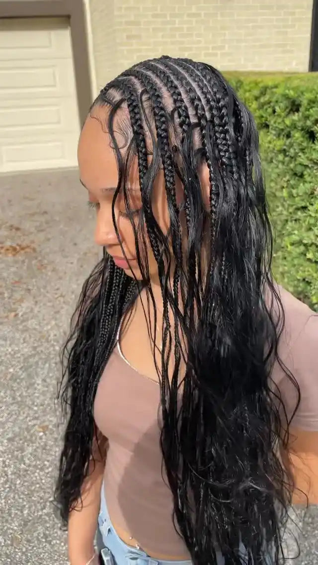 Person with braided hair standing outdoors on a driveway.