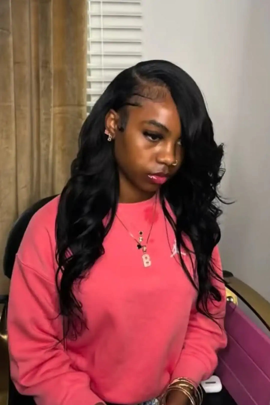 Person wearing a pink sweatshirt with a blurred background