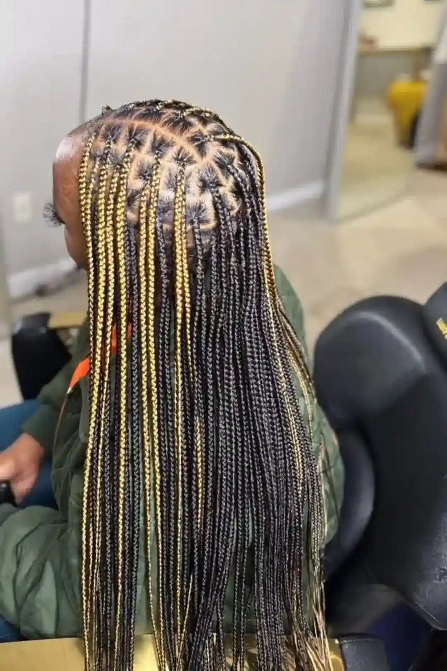 Person with braided hair in a salon setting