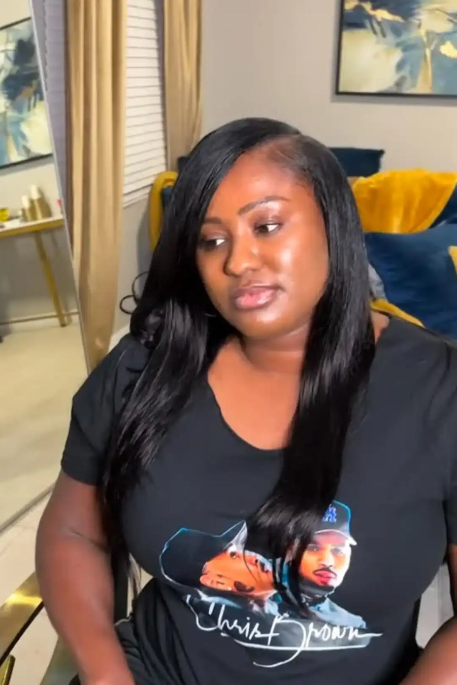Woman wearing a black t-shirt with a graphic design in a living room setting
