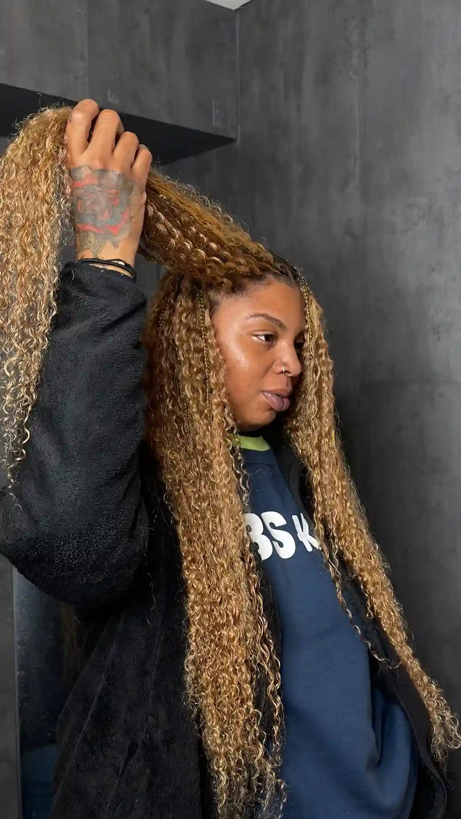 Person with long, styled hair against a dark background