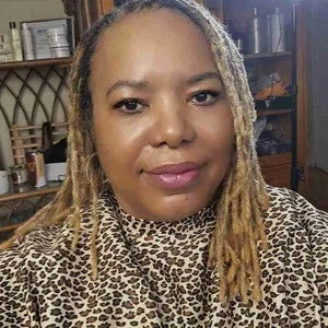 Person wearing a leopard print top in an indoor setting