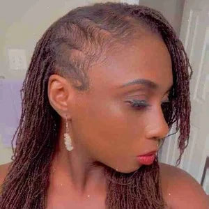 Woman with braided hair wearing sunglasses indoors