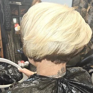 Person with a styled blonde wig in a salon setting