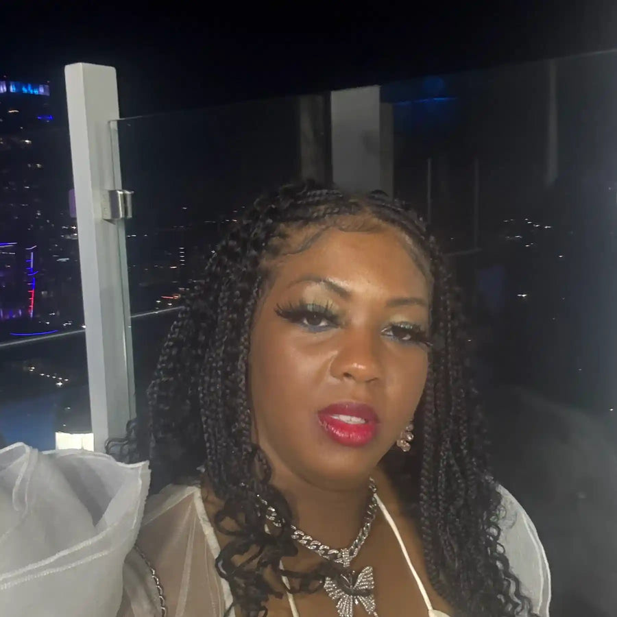 Woman with braided hair and red lipstick in a cityscape at night