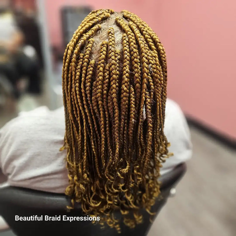 Person with braided hair sitting in a chair, with 'Beautiful Braid Expressions' branding.
