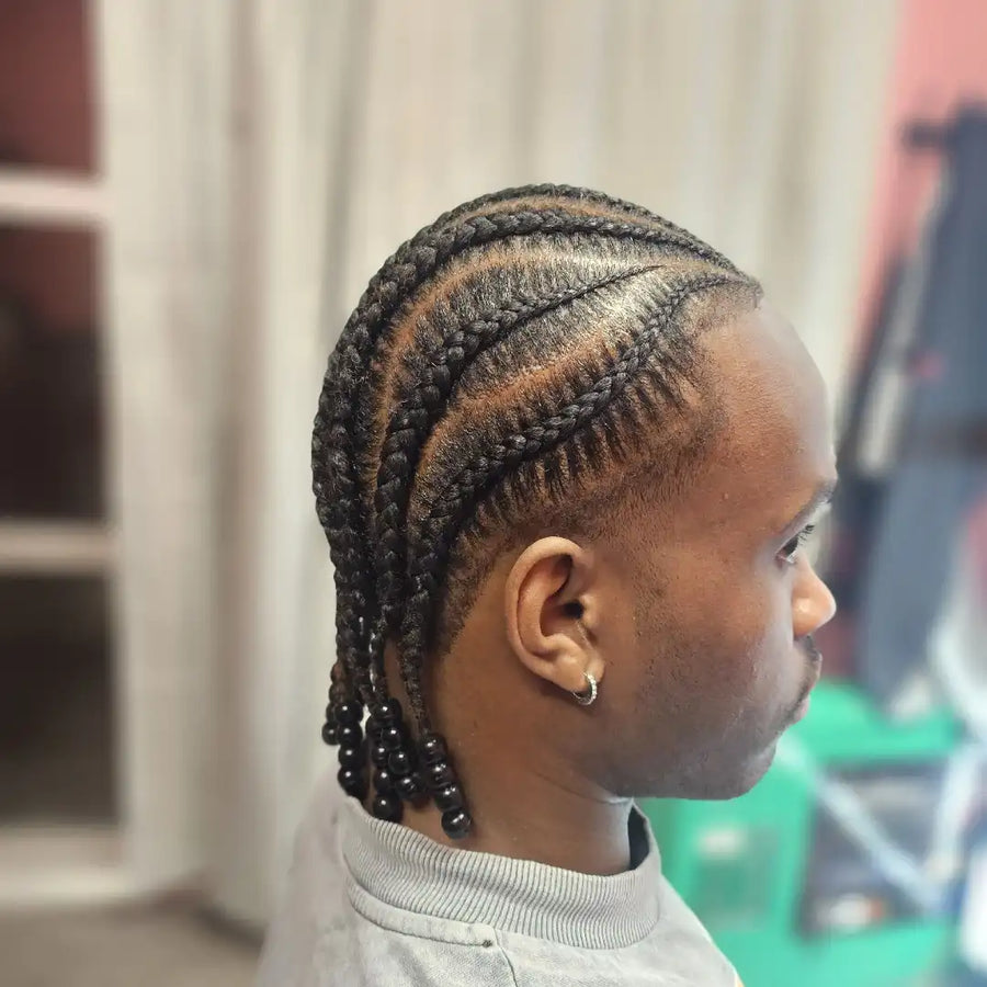 Person with braided hair in a blurred indoor setting