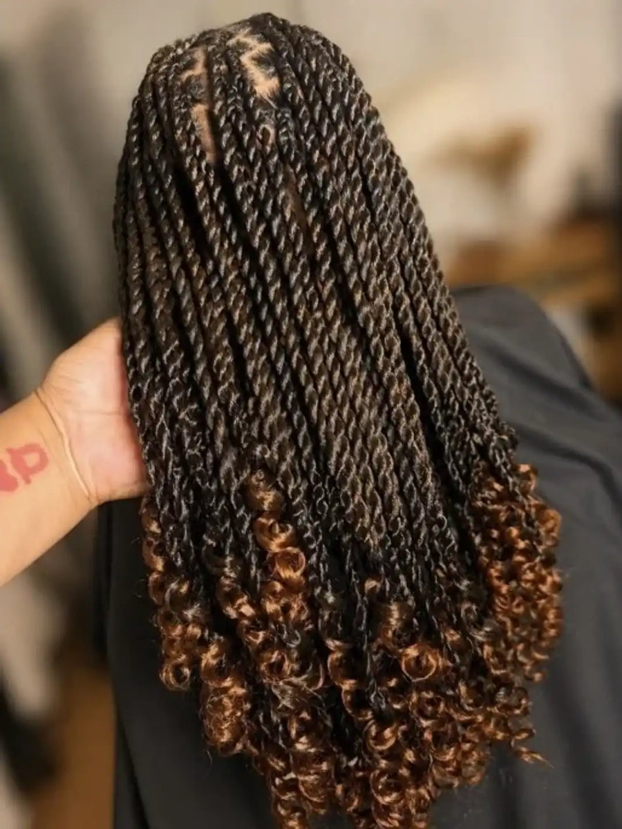 Braided hair extensions held by a hand with a blurred background