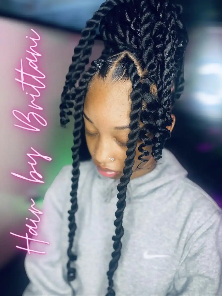 Person with braided hair wearing a white sweater, with 'Hair by Brittani' text on the side.