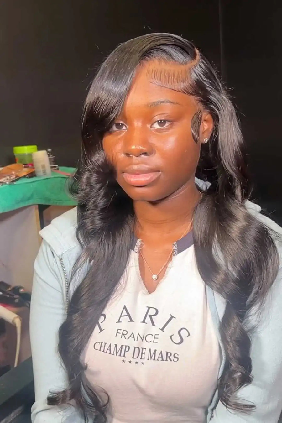 Woman with styled hair wearing a hoodie with text in an indoor setting