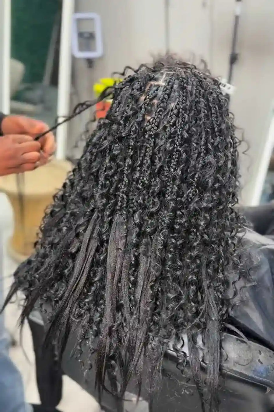 Person with braided hair being styled in a salon setting