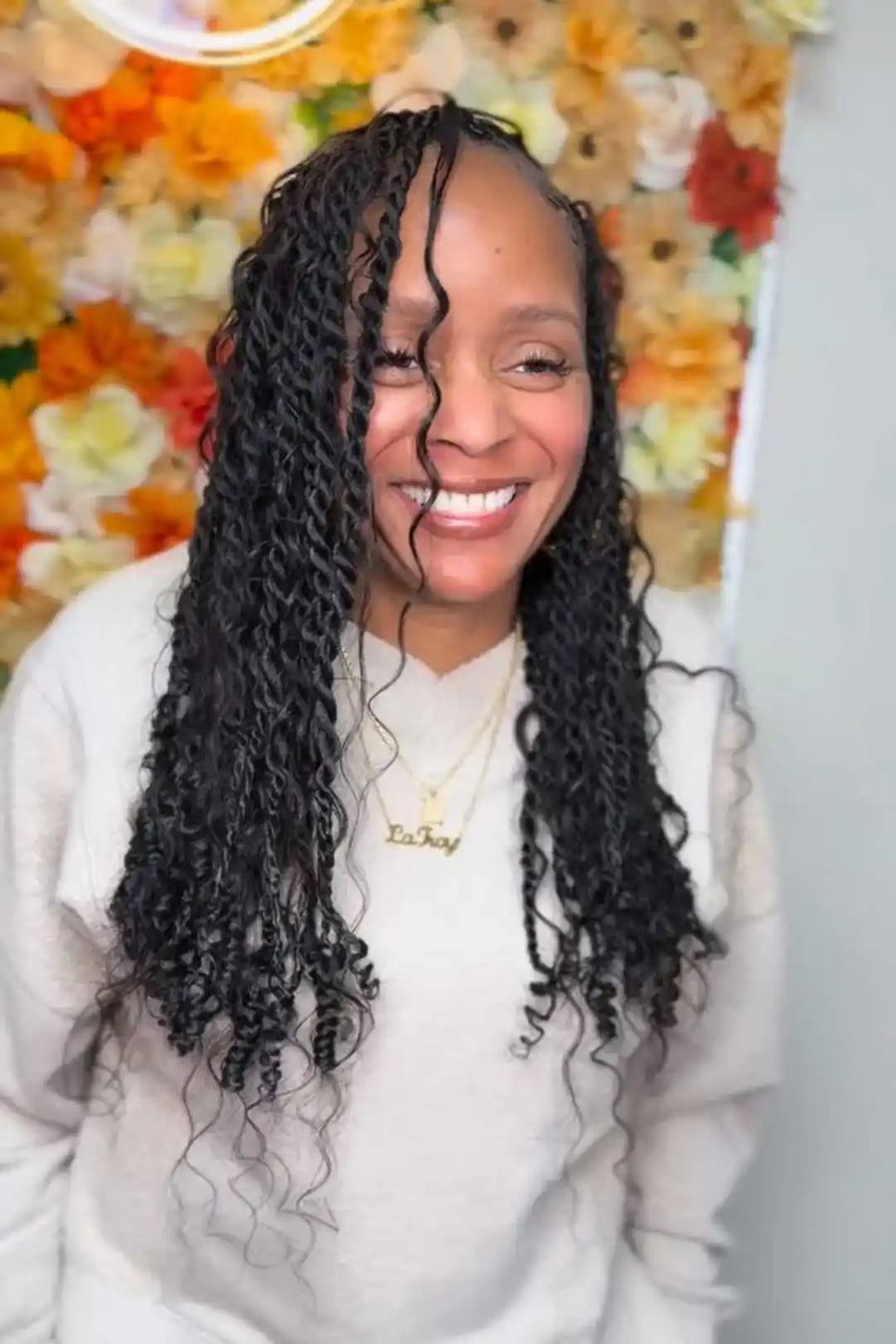 Woman with styled hair in front of a floral background