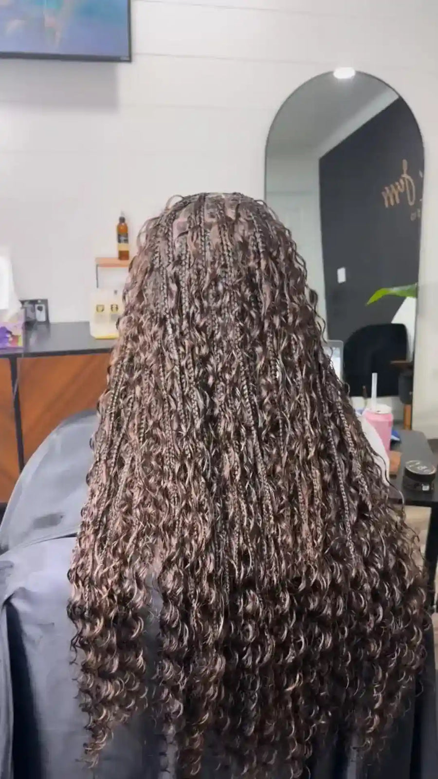 Person with long, curly hair in a salon setting