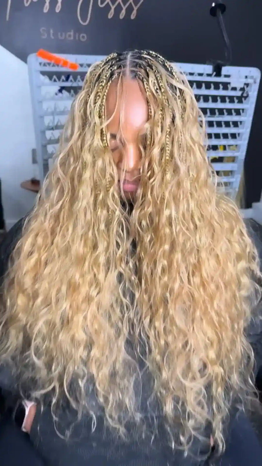 Person with long, wavy blonde hair in a salon setting.