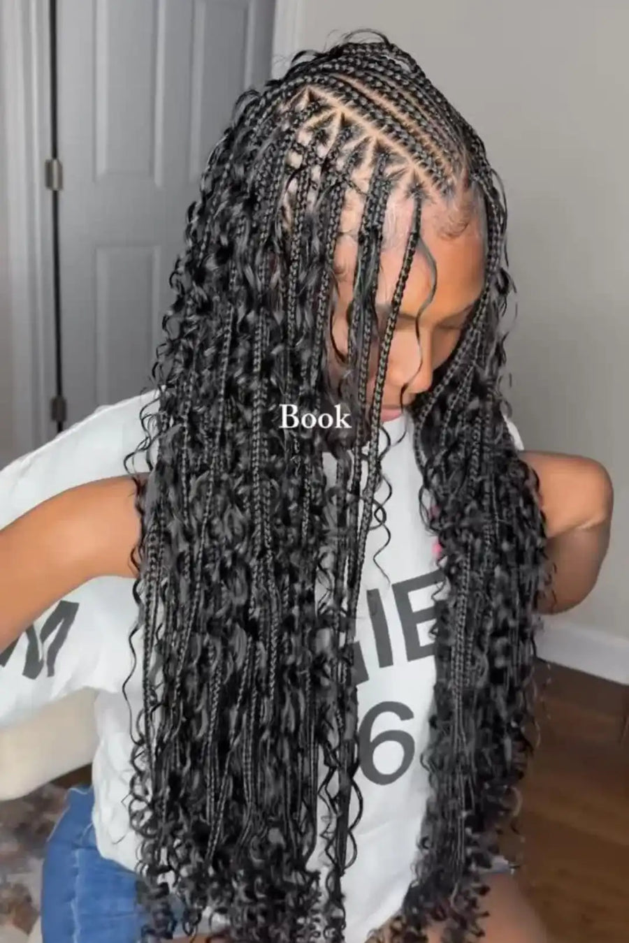 Person with braided hair wearing a white shirt with text