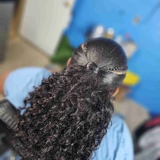 Person with a large afro hairstyle wearing a blue shirt and gloves.