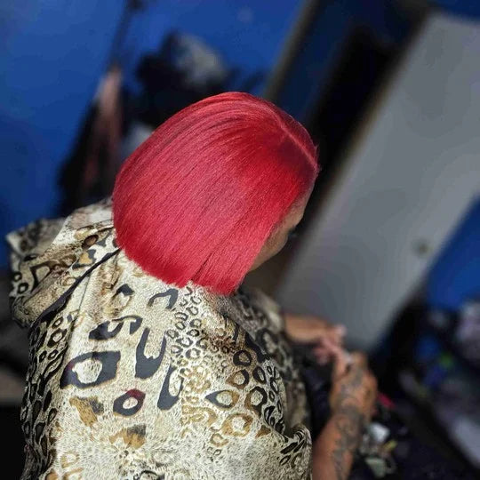 Person with red hair wearing a patterned shirt in an indoor setting