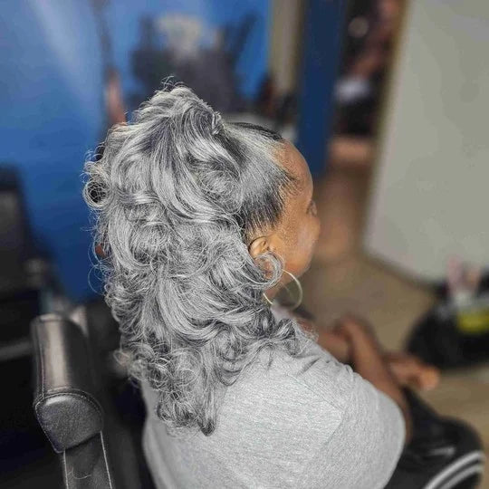 Person with gray hair sitting in a chair with a blurred background