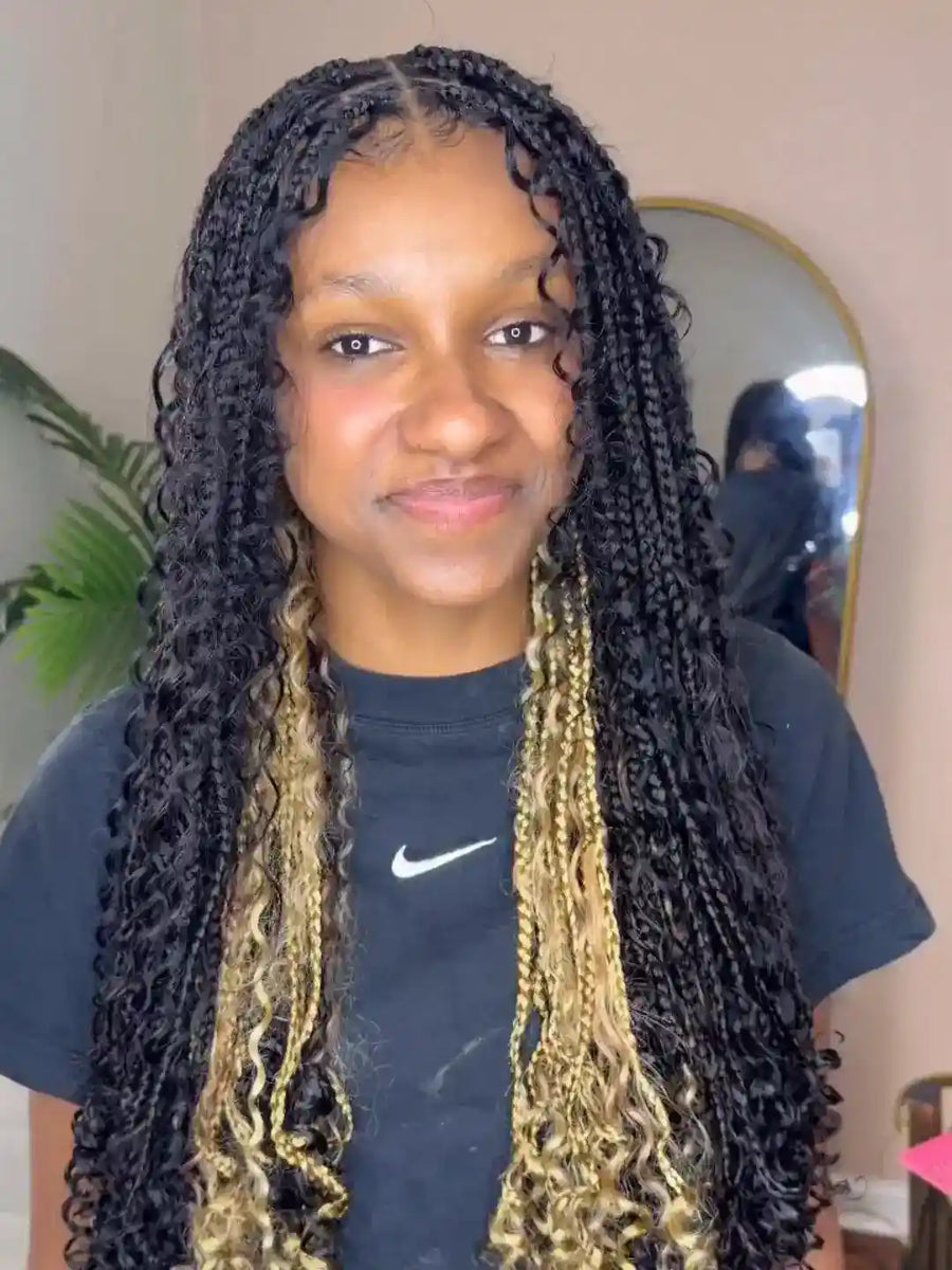 Person with braided hair wearing a dark blue Nike shirt indoors.