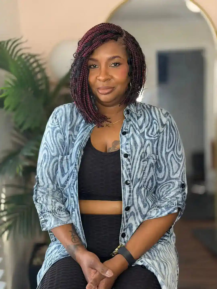 Woman wearing a patterned shirt in an indoor setting with plants