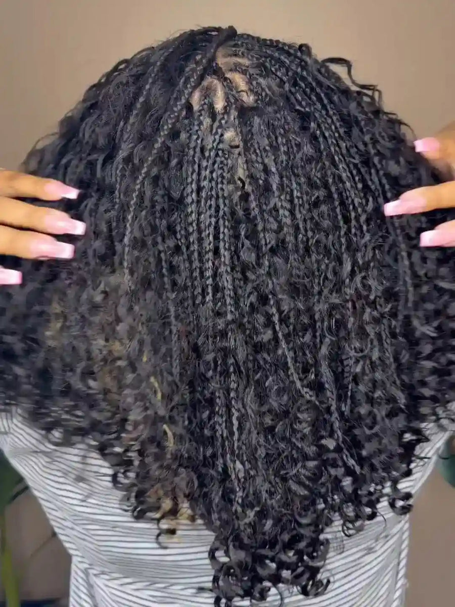 Close-up of a person with braided hair, wearing a striped shirt.