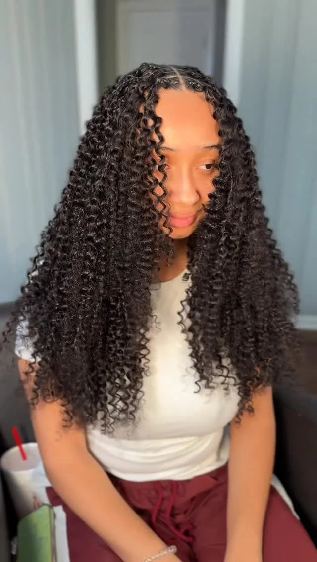 Person with long, curly hair sitting indoors.