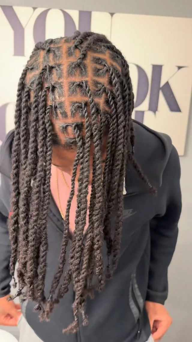 Person with braided hair in front of a blurred background