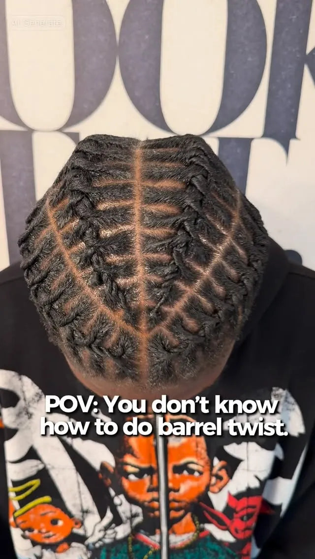 Person with intricately styled hair, wearing a hoodie with graphic designs.
