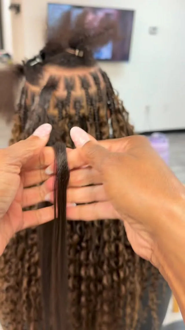 Person holding a section of braided hair with a blurred background