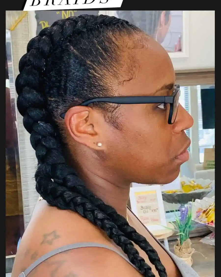 Person with braided hair wearing glasses in a casual setting