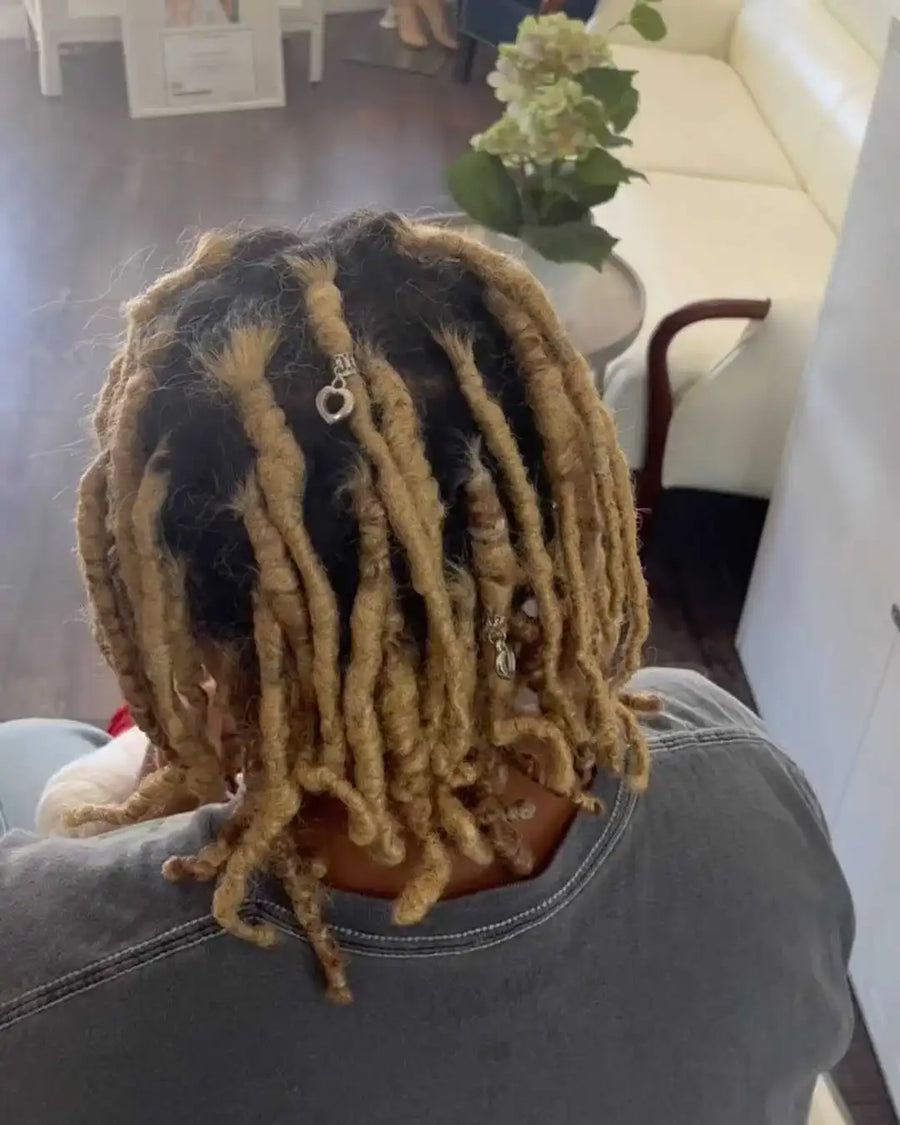 Person with styled dreadlocks in a living room setting