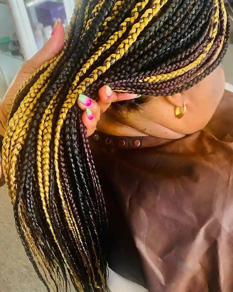 Person with braided hair featuring black, yellow, and brown colors.
