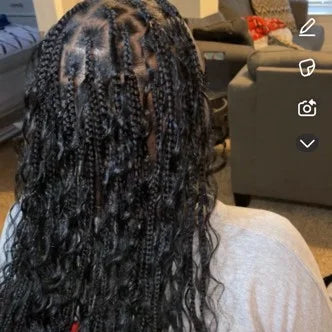Person with braided hair in a living room setting