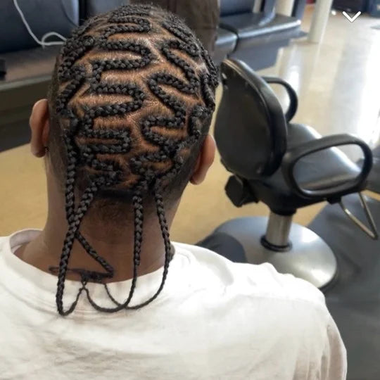 Person with intricately braided hair in a salon chair.