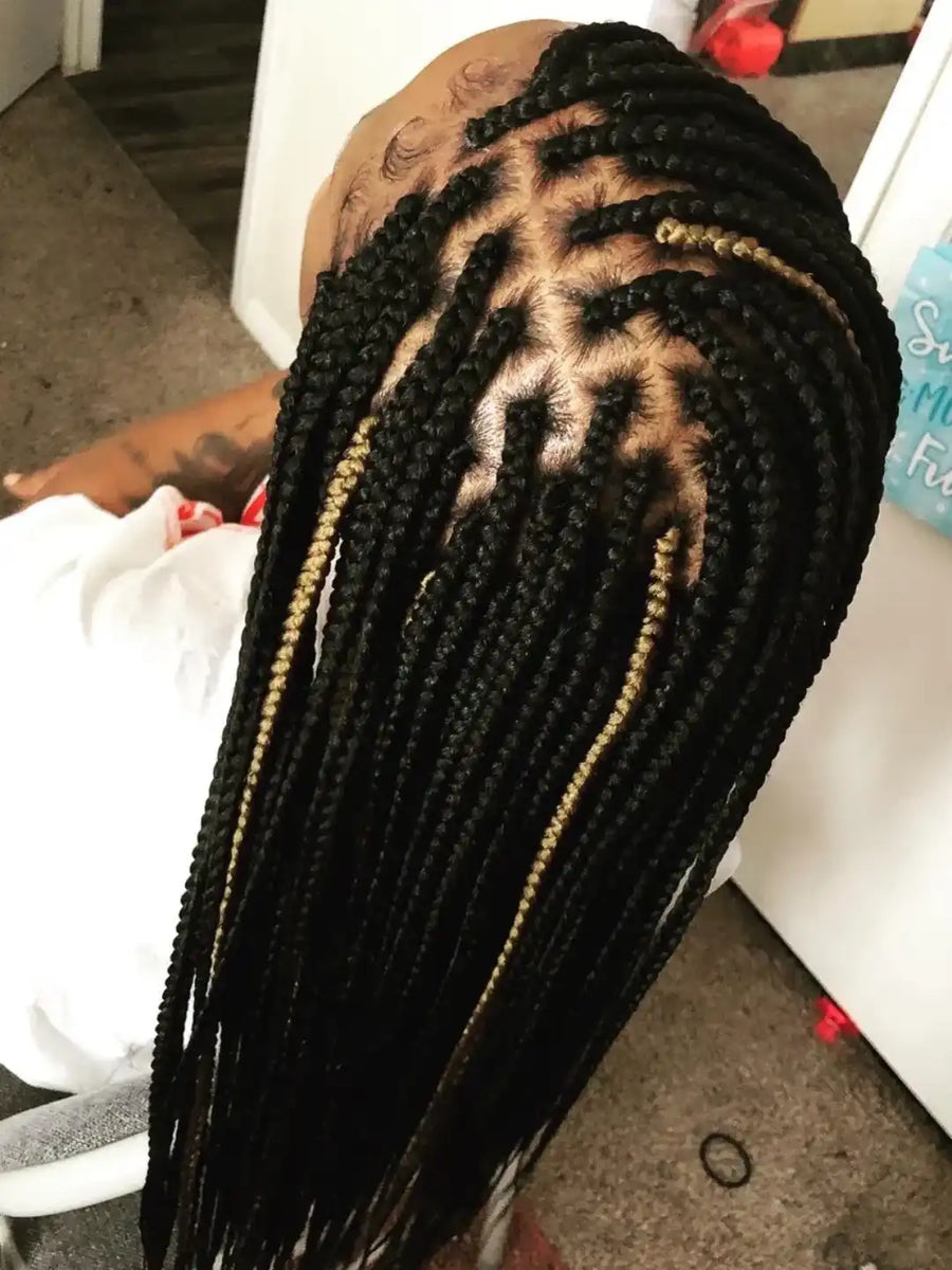Person with braided hair sitting on a couch.