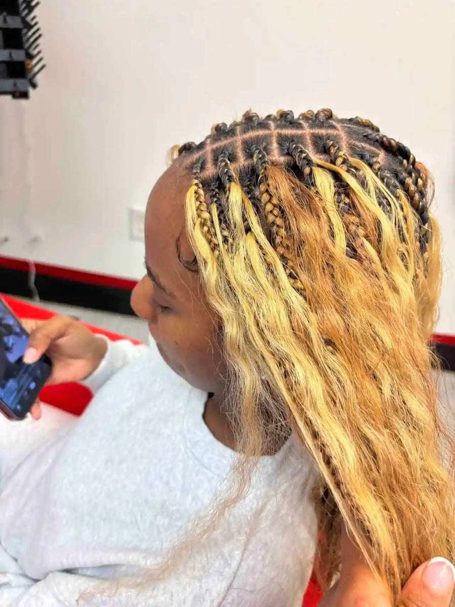 Person with braided hair in a salon setting