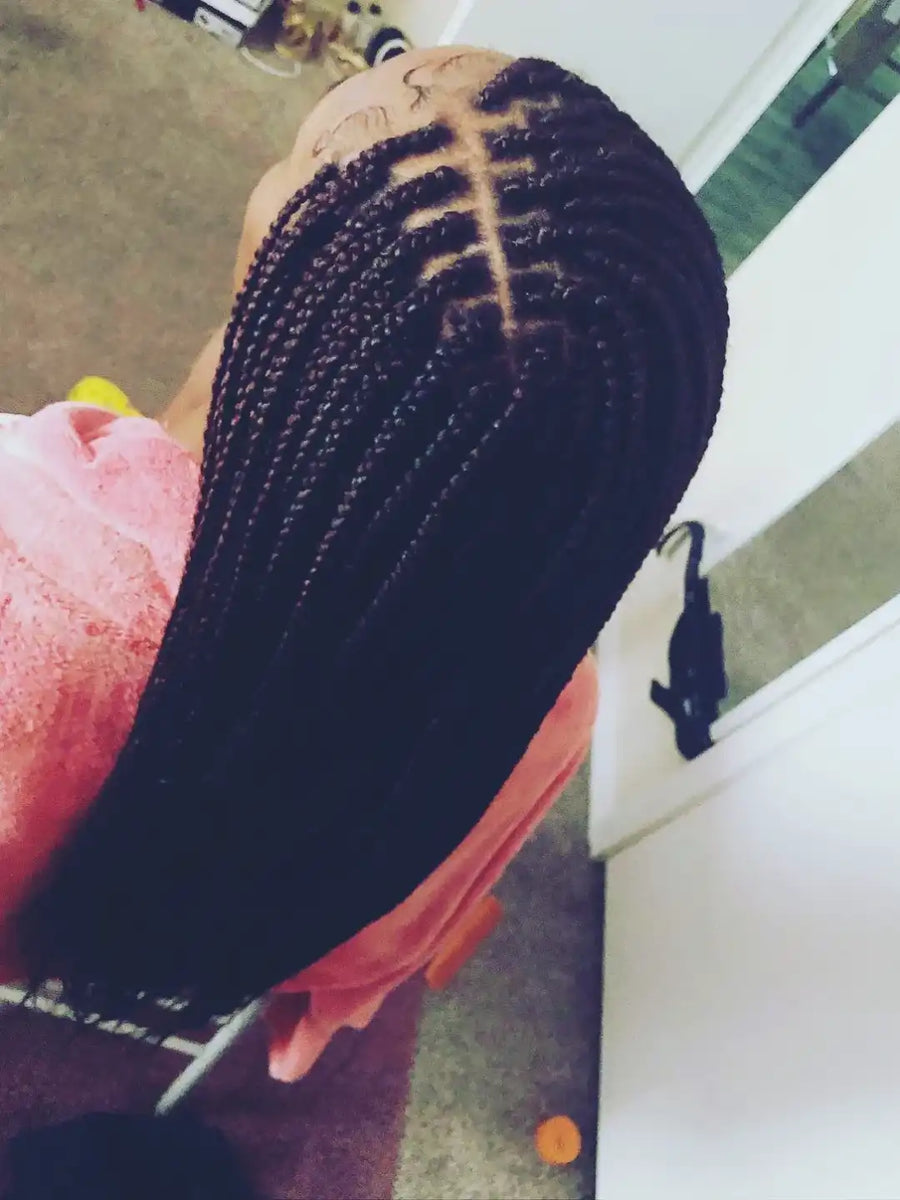 Person with braided hair in a salon setting