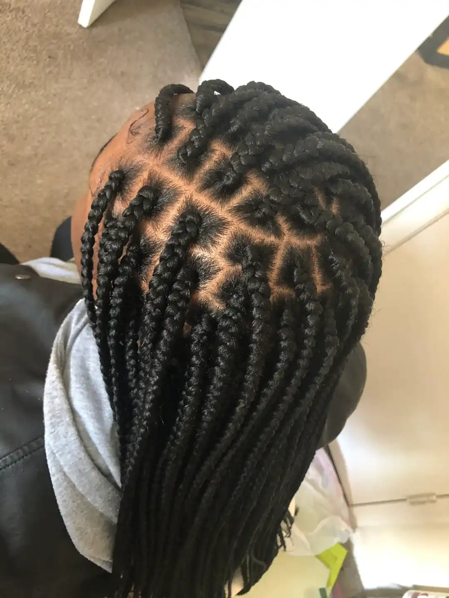 Person with intricate braided hairstyle in a casual setting