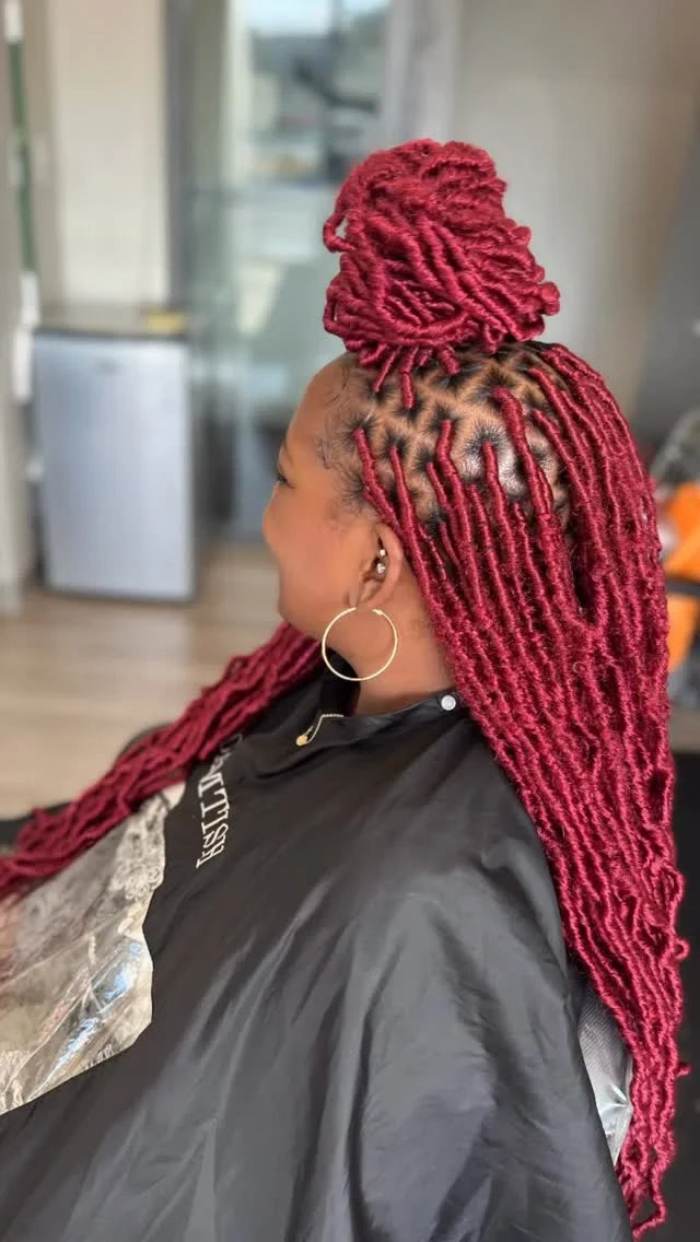 Person with red braided hair in a salon setting