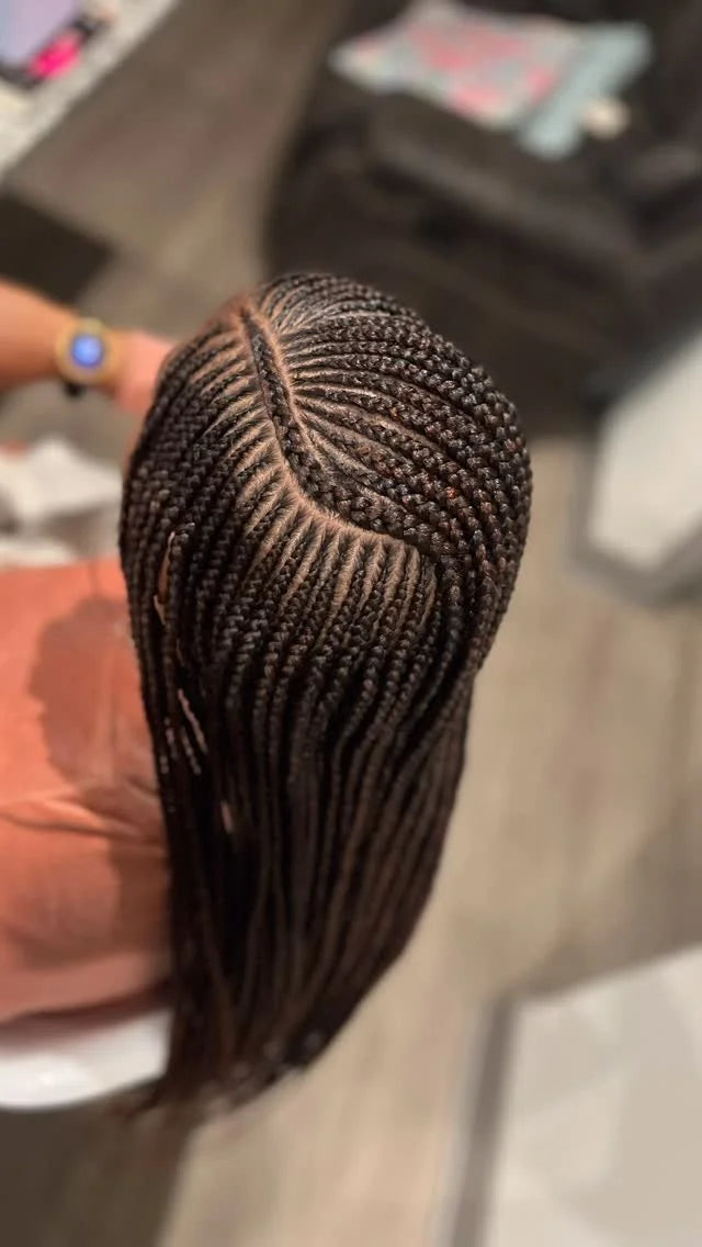 Close-up of braided hair extensions held by a person with a blurred background