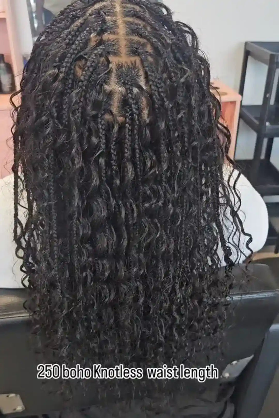 Close-up of a person with long, styled hair with text indicating '250 boho knotless waist length'.