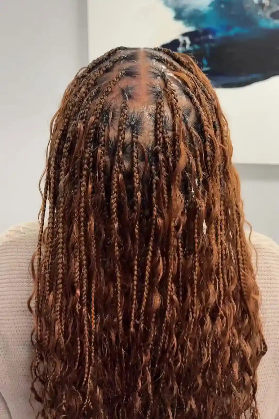 Person with long braided hair in a neutral setting