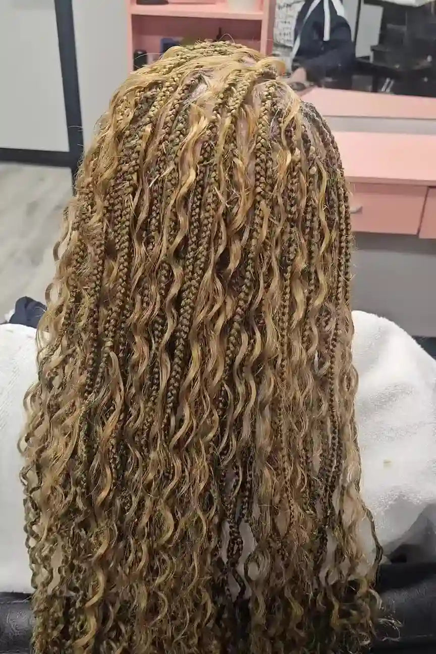 Close-up of a person with long, braided hair in a salon setting.