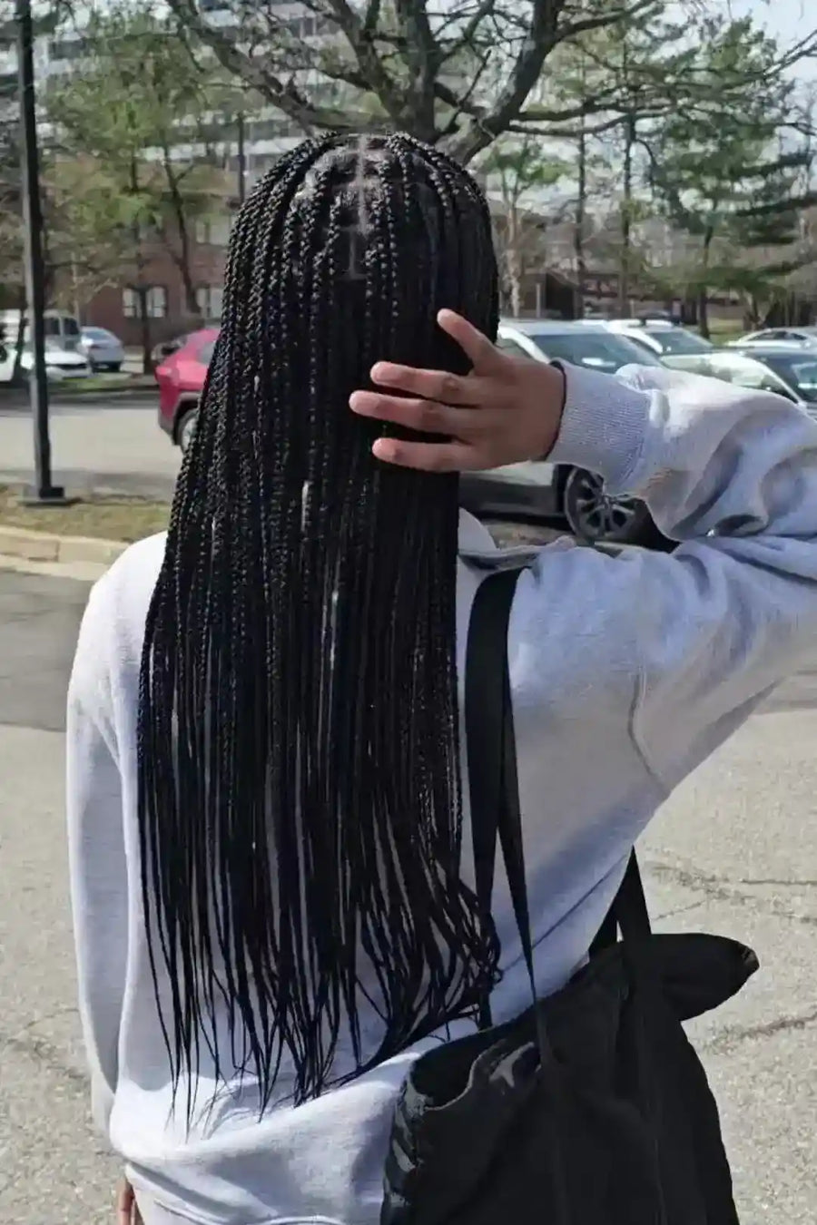 Person with long braided hair in an urban setting
