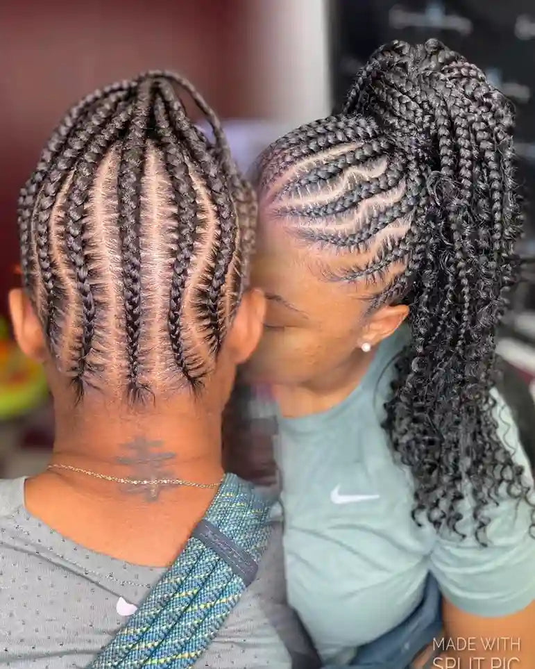 Two women with braided hairstyles looking at each other, with a blurred background.