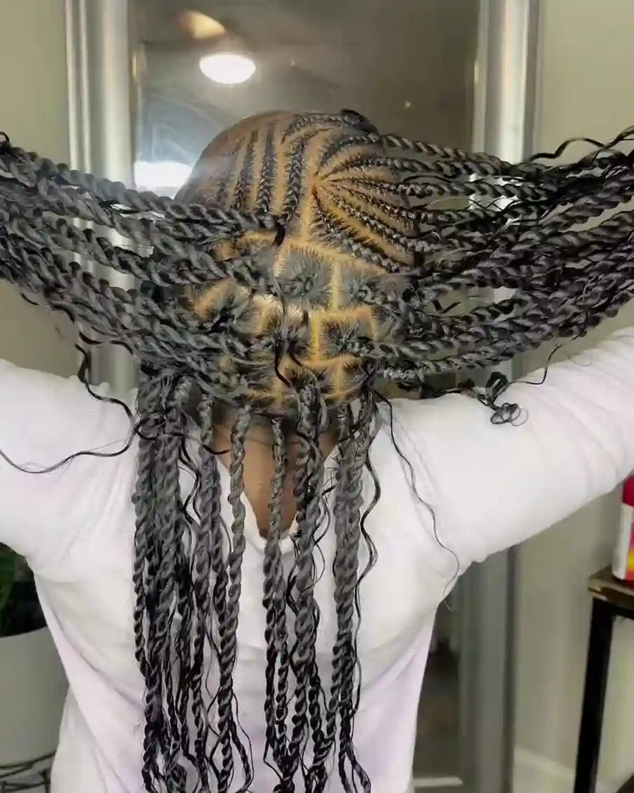 Person with braided hair styled in a decorative manner, wearing a white garment.