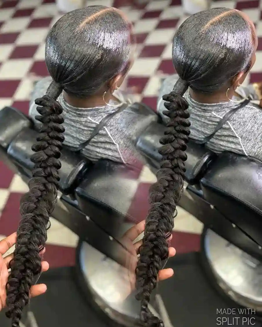 Two braided ponytails held by hands against a checkered floor background.
