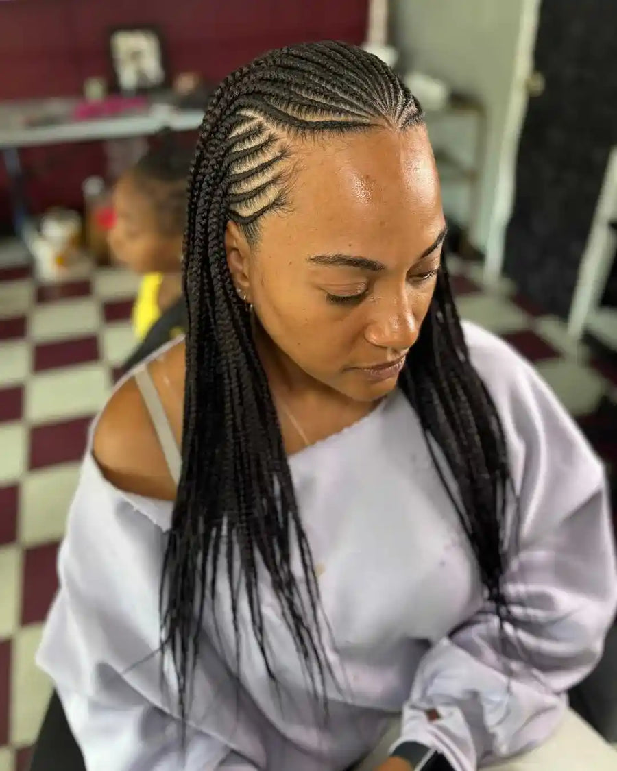 Woman with braided hair sitting in a salon chair.