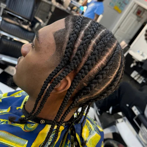 Person with braided hair in a salon setting